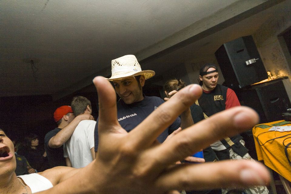 Blurred hand in front of a grinning man in a straw hat