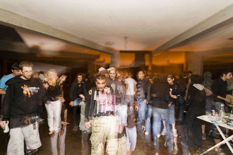 Blurred crowd dancing in a dim concrete hall