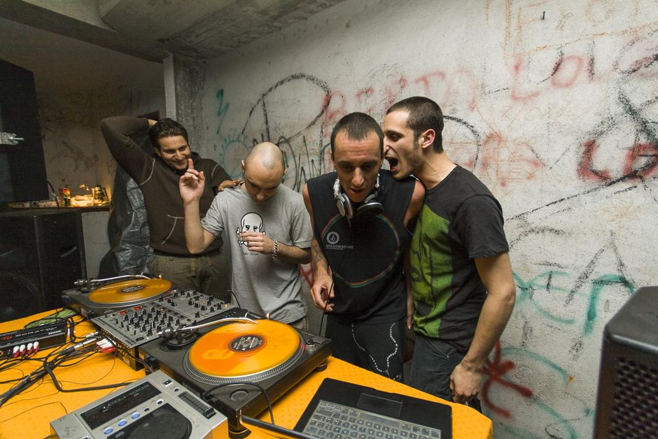 Friends laughing and shouting behind the DJ decks