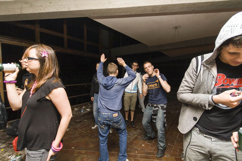 Guests dancing on a brick-paved floor in a bare hall