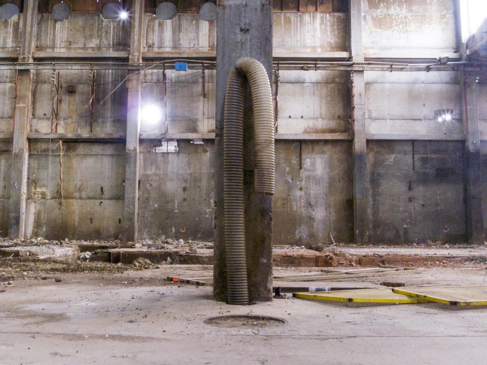 Flexible hose looped around a column in a stripped hall