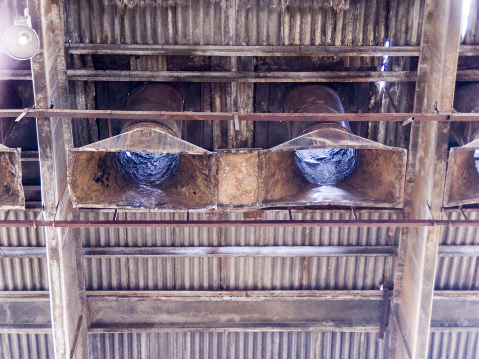Rusty extraction hoods and ducts under a corrugated roof