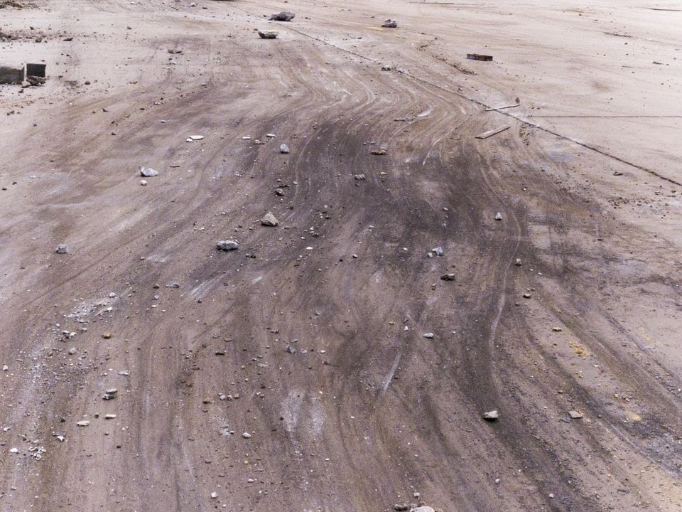 Tyre skid marks across bare dusty ground