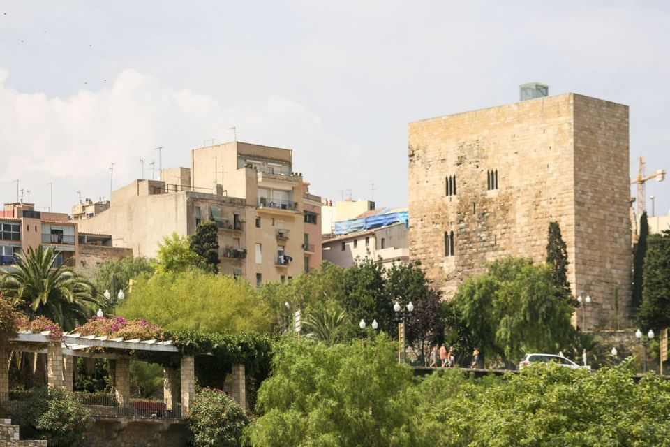 Square stone tower above rooftops and green gardens