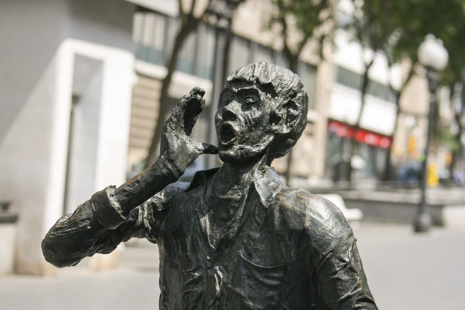 Bronze figure shouting with a hand cupped at the mouth