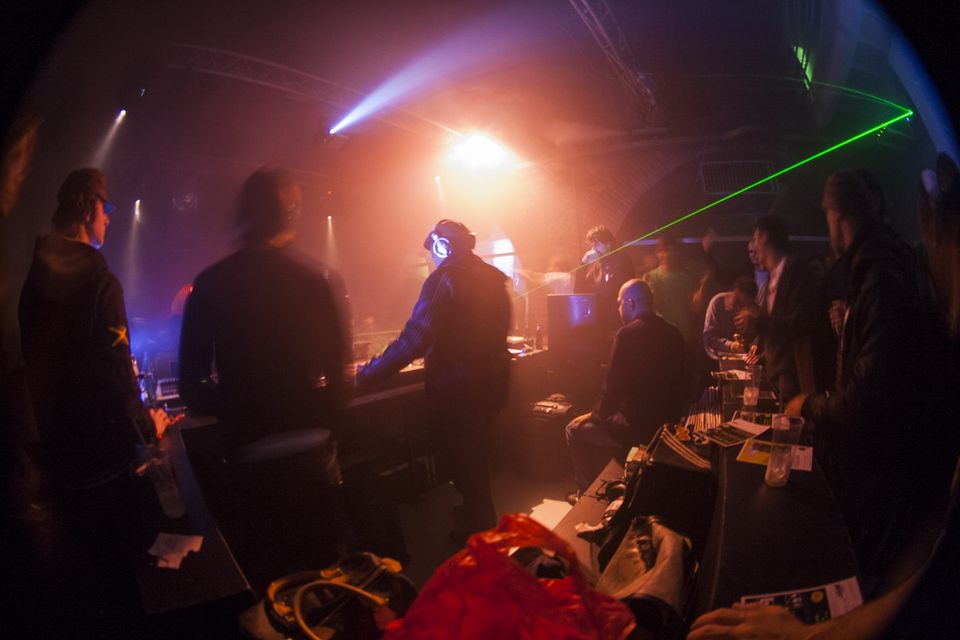 Laser beam and haze over a crowd beside the DJ booth