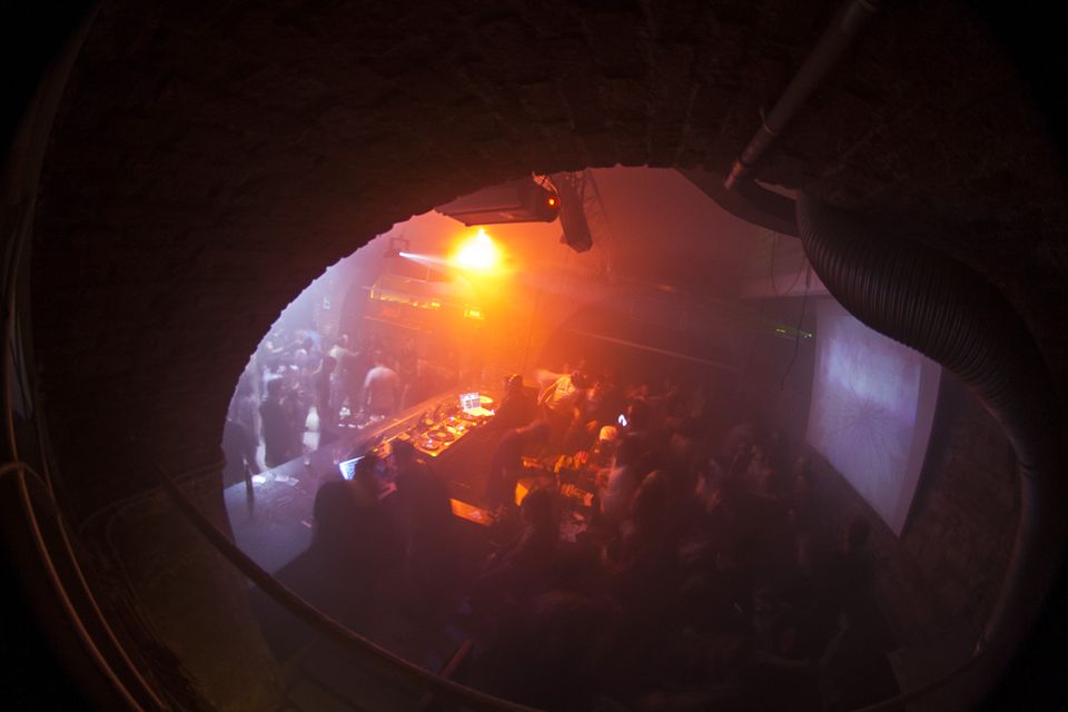 Looking down from an arched brick opening onto the crowded dancefloor