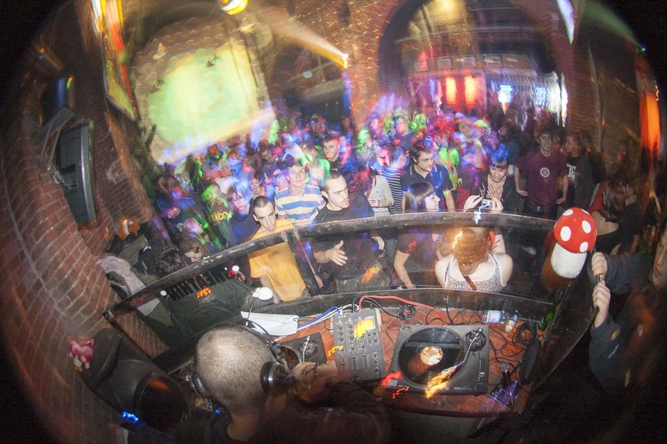 Fisheye view over the decks to a packed brick-vaulted dance floor