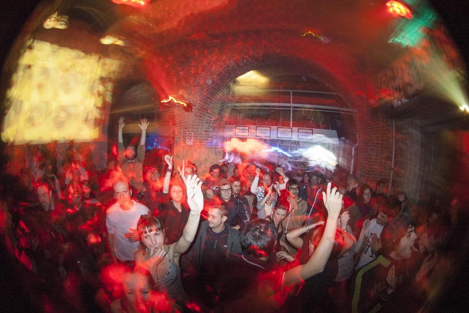 Red mushroom lamp on a turntable with two DJs behind the booth