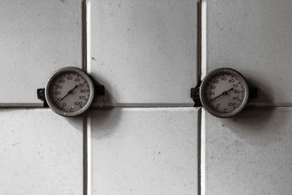 Two pressure gauges mounted on white tiles