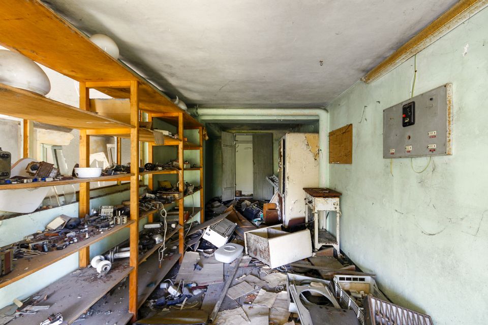 Storeroom shelves of scattered tools, appliances and debris