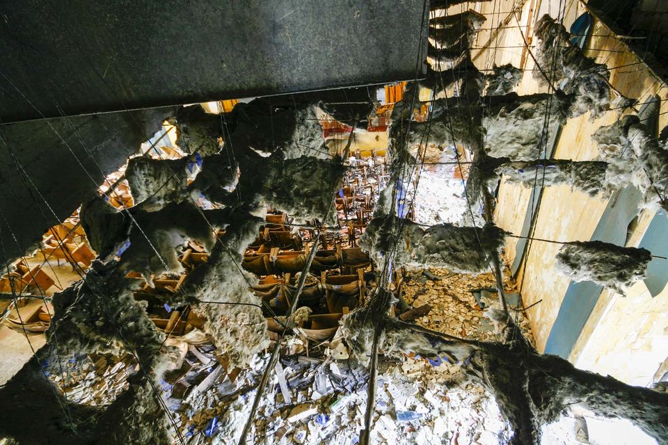 Collapsed ceiling hanging with insulation above a wrecked room