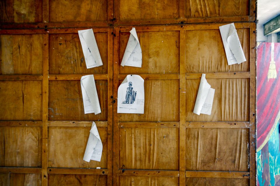 Wooden panel wall with loose paper sheets pinned on it