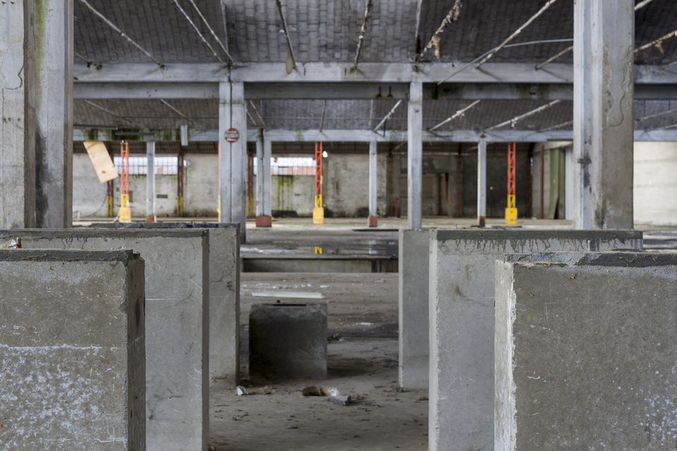 Concrete blocks in the foreground of a hall with painted columns