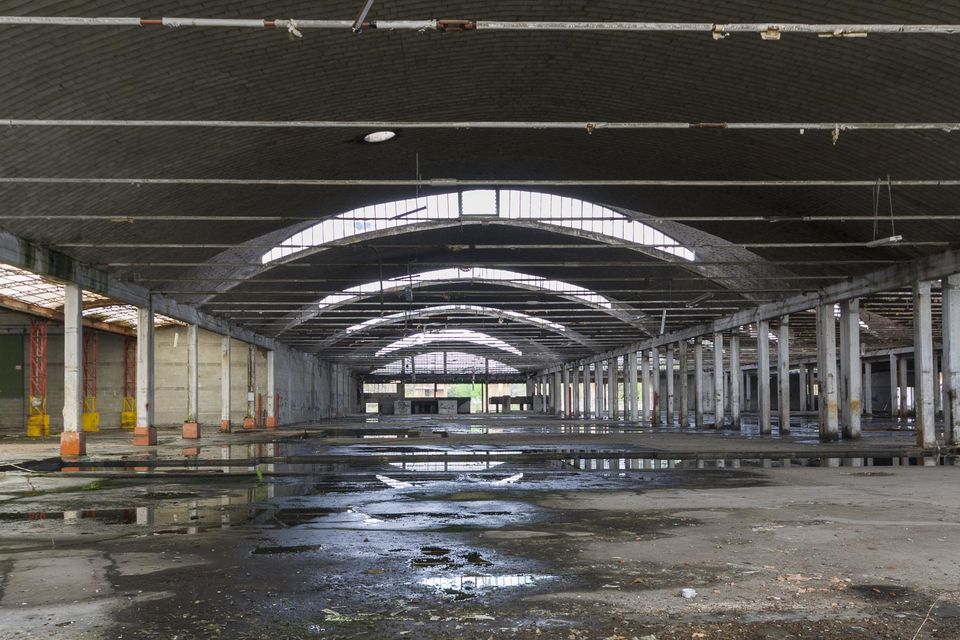 Long arched factory hall with a wet reflective floor