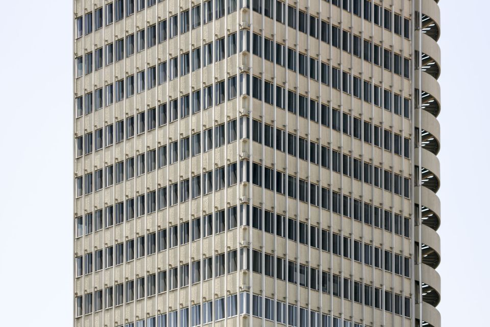 Tall cream office tower with a grid of narrow windows