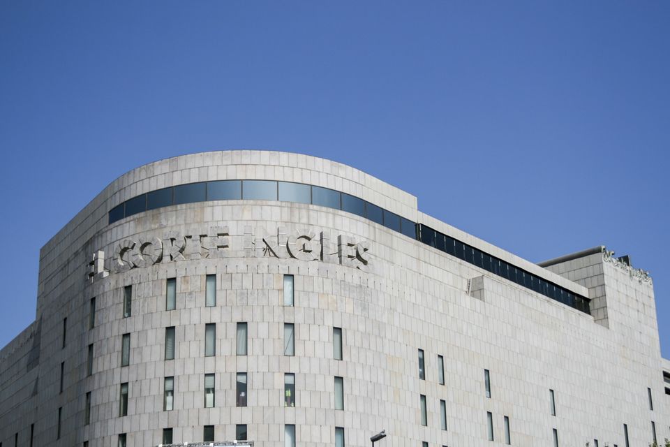 Curved stone facade of a department store against blue sky