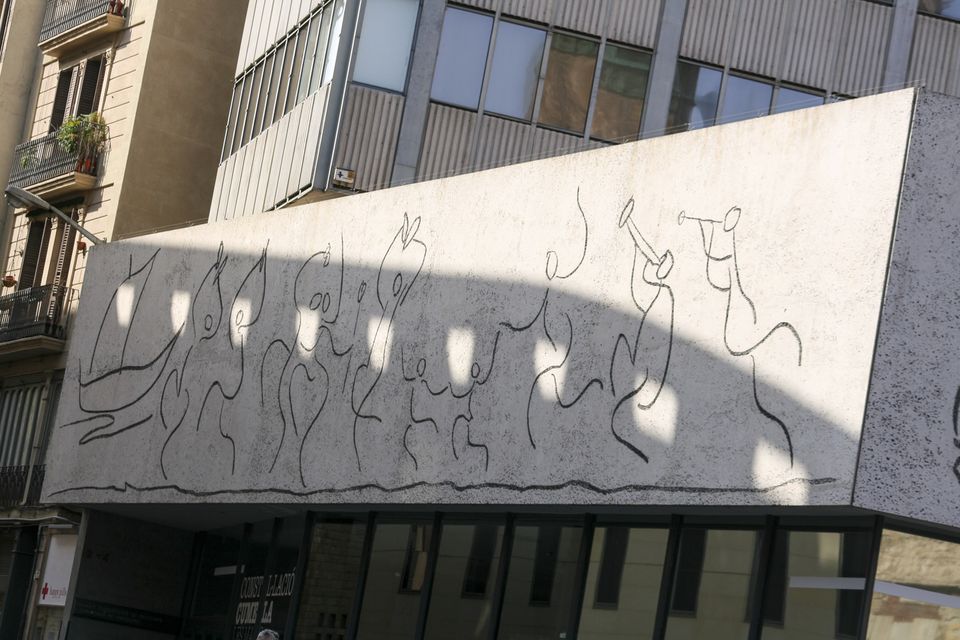 Sketched frieze of dancing figures on a concrete facade