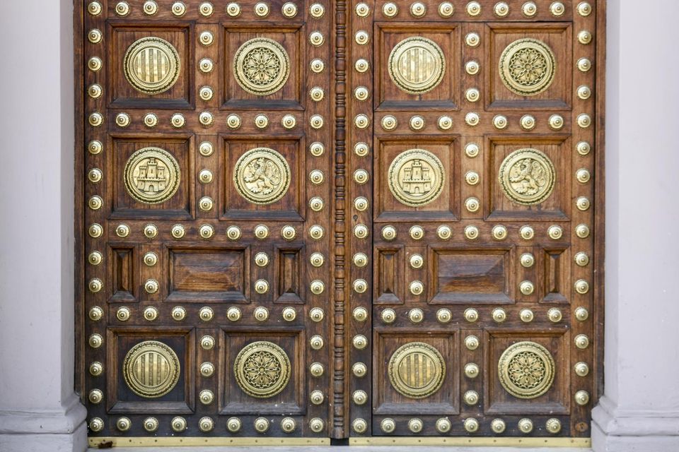 Studded wooden doors with brass medallions