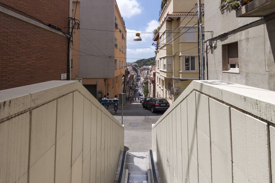 View down a steep street from a hillside escalator