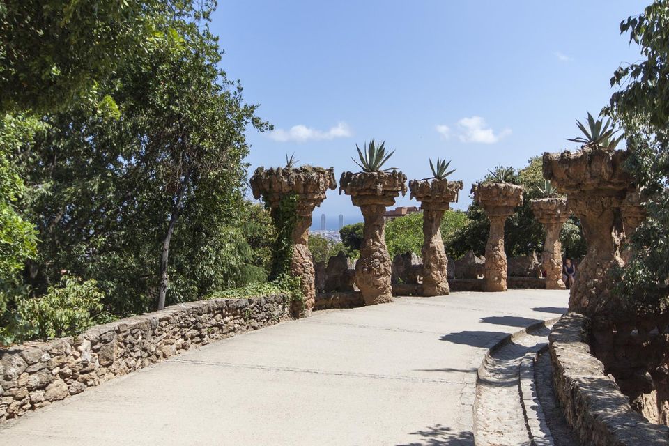 Stone columns topped with agave plants beside a curved wall