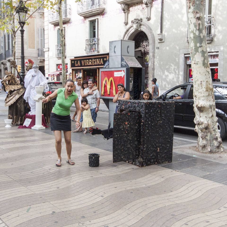 Woman startled by a performer hiding in a black box