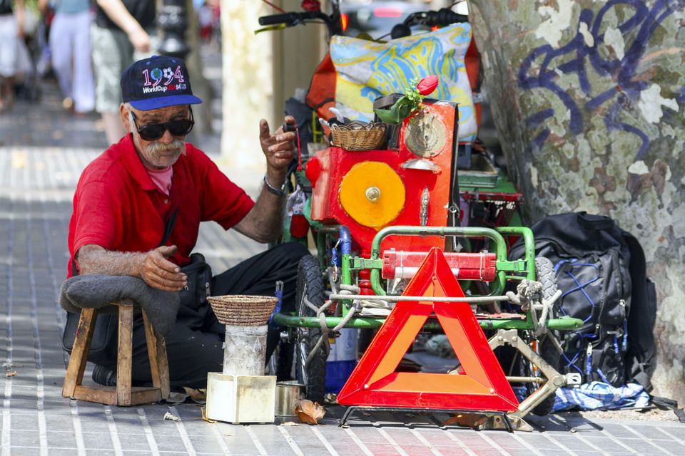 Man in a red shirt on a stool beside a decorated cart