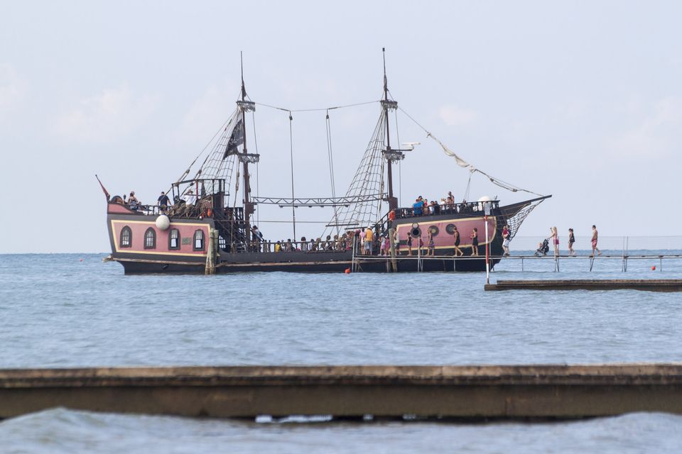 Pirate ship tour boat anchored beside a breakwater