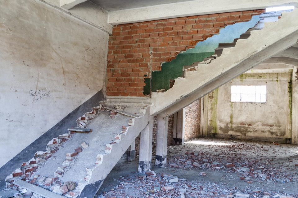Collapsed concrete staircase and rubble in a gutted building