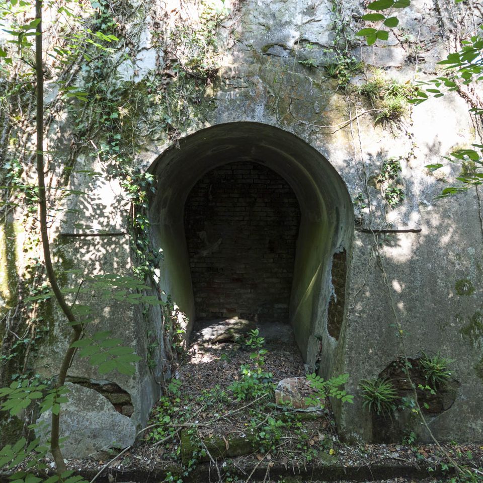 Arched concrete opening with a bricked-up back wall