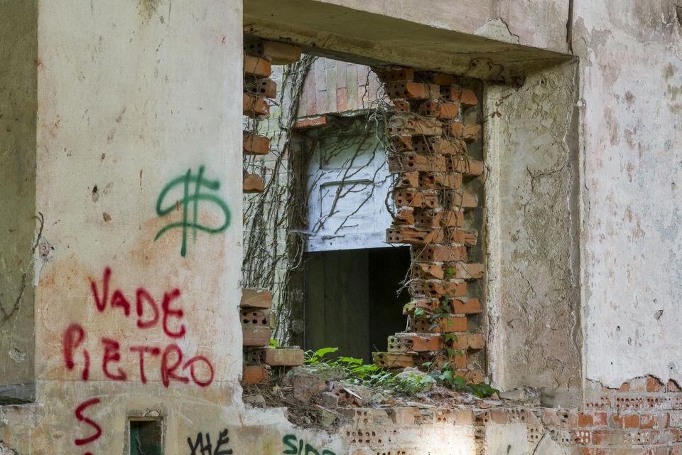 Window opening in a brick wall with graffiti