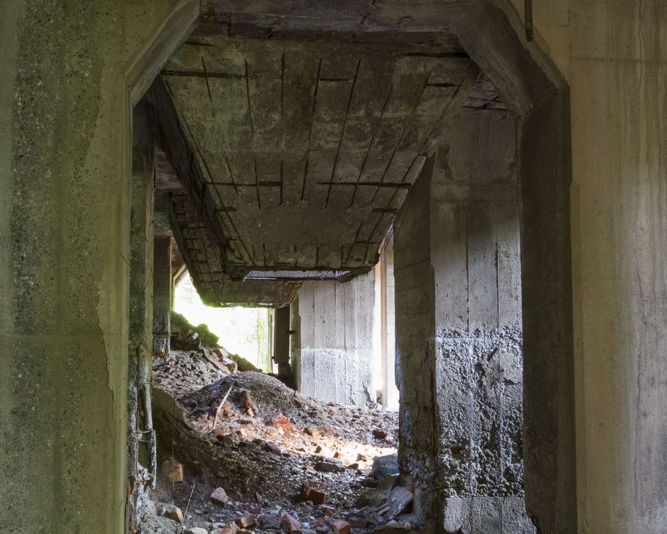 Concrete passage with rubble and a collapsed slab above