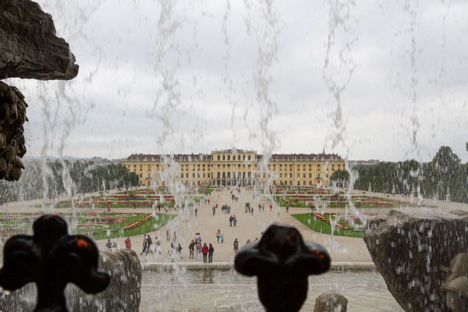Palace and gardens seen through the falling water of a fountain