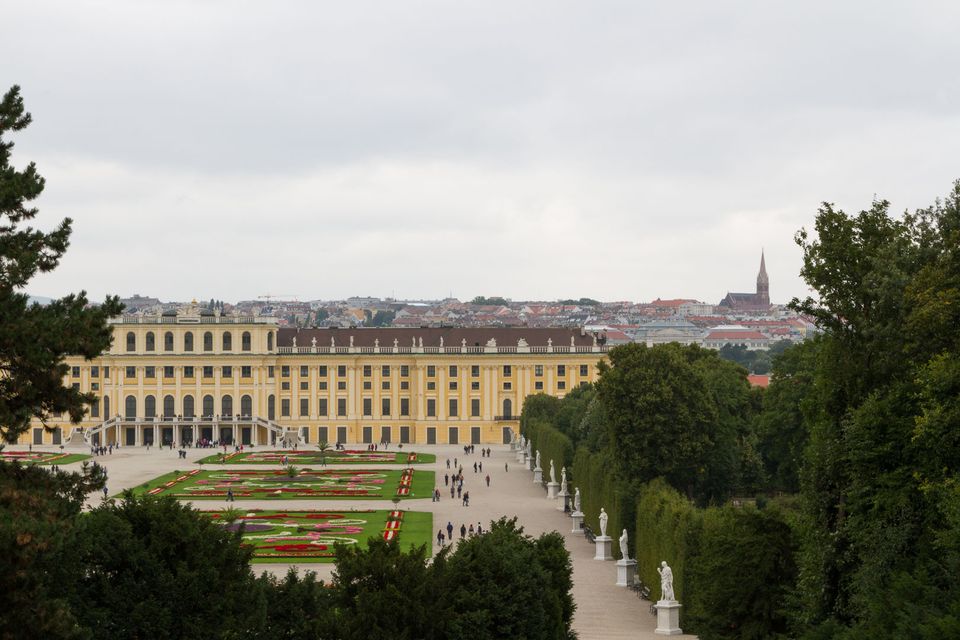 Yellow palace and flower parterres seen from the hill, city beyond