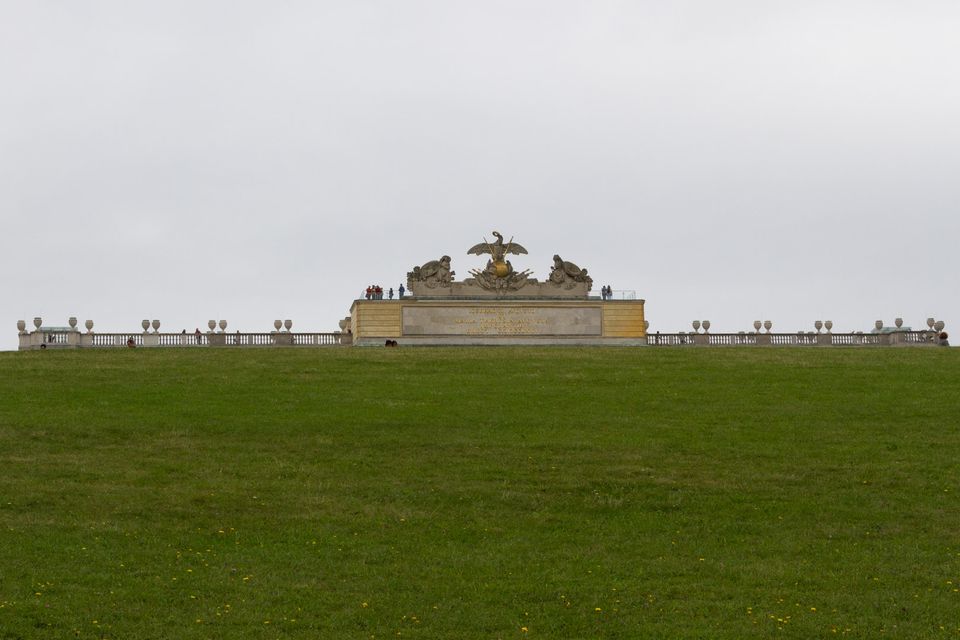 Hilltop colonnade seen over a steep green lawn