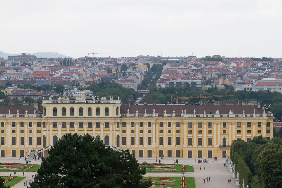 Long yellow palace below a haze-covered panorama of rooftops