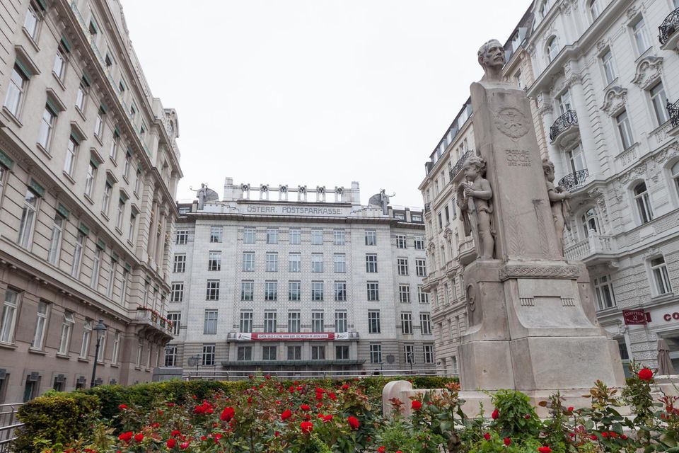 Monument and rose bed in front of a cream office block