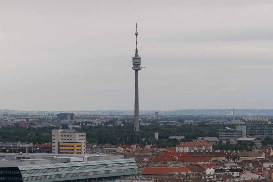 Television tower rising above rooftops in haze