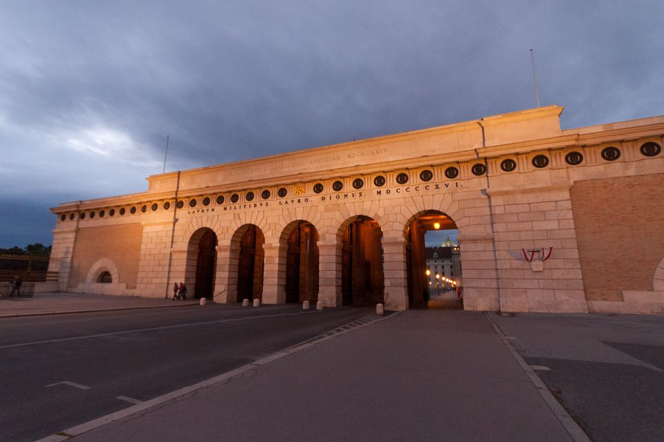 Gateway arches glowing at dusk under dark clouds