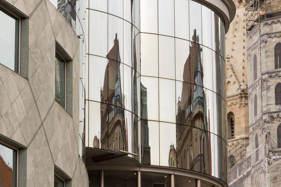 Curved glass facade reflecting the cathedral’s Gothic spire