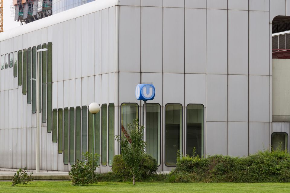 Blue U-Bahn sign in front of a pale panelled building