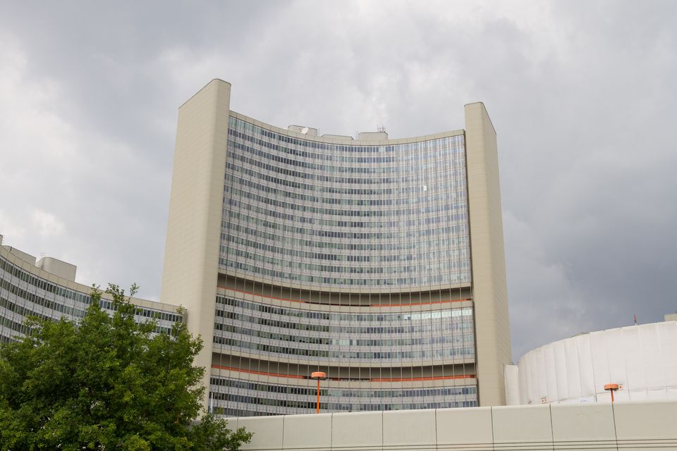 Curved tower block of an international office complex under grey clouds