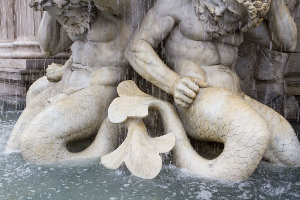Two bearded sea gods with fish tails in a splashing fountain