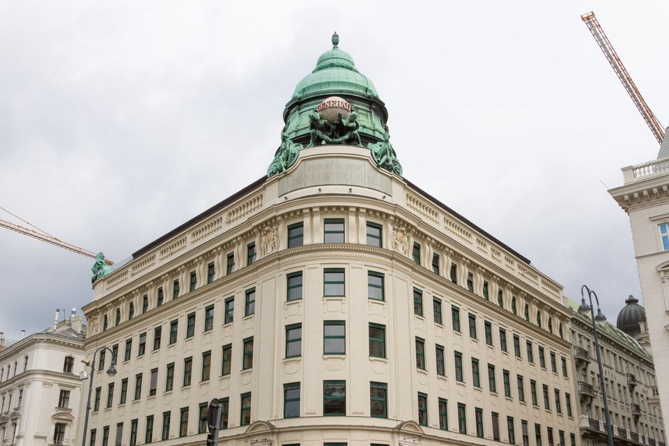 Corner building with a green copper dome and sculpted figures
