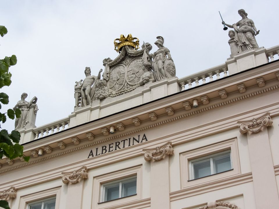 Cornice with sculpted coat of arms and golden crown above Albertina lettering