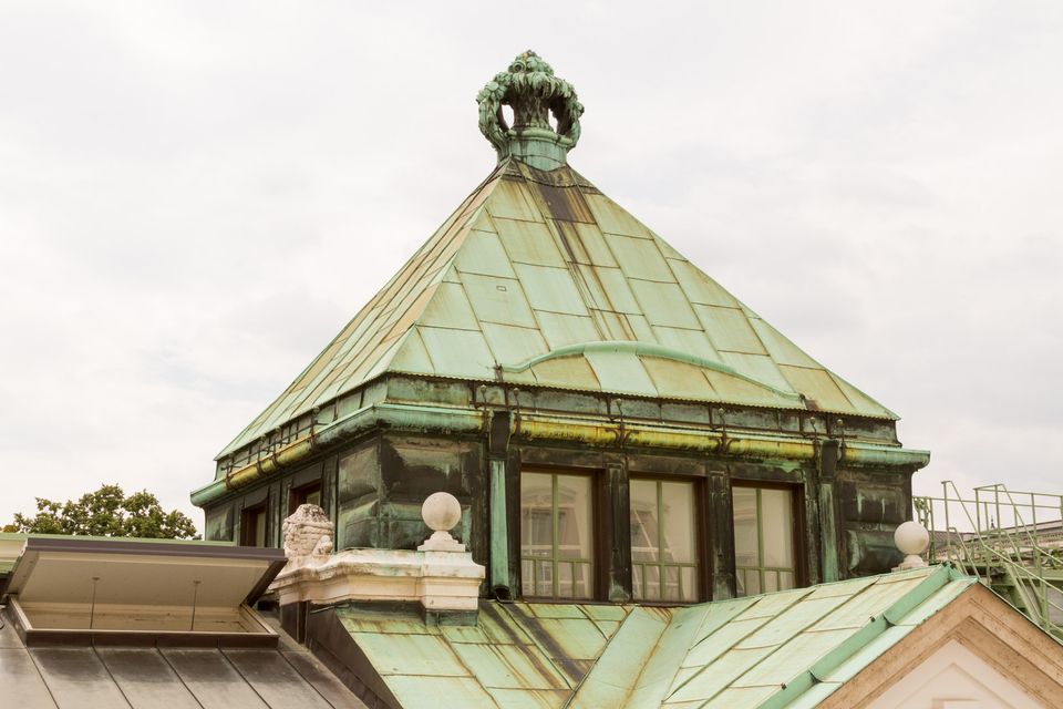 Verdigris pyramid roof topped with a stone crown
