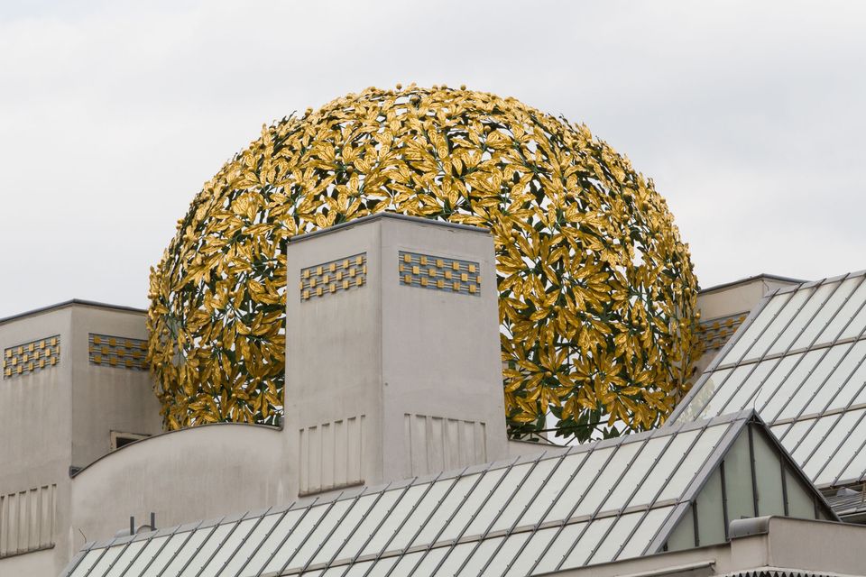 Dome of golden laurel leaves above a pale building with glass roof