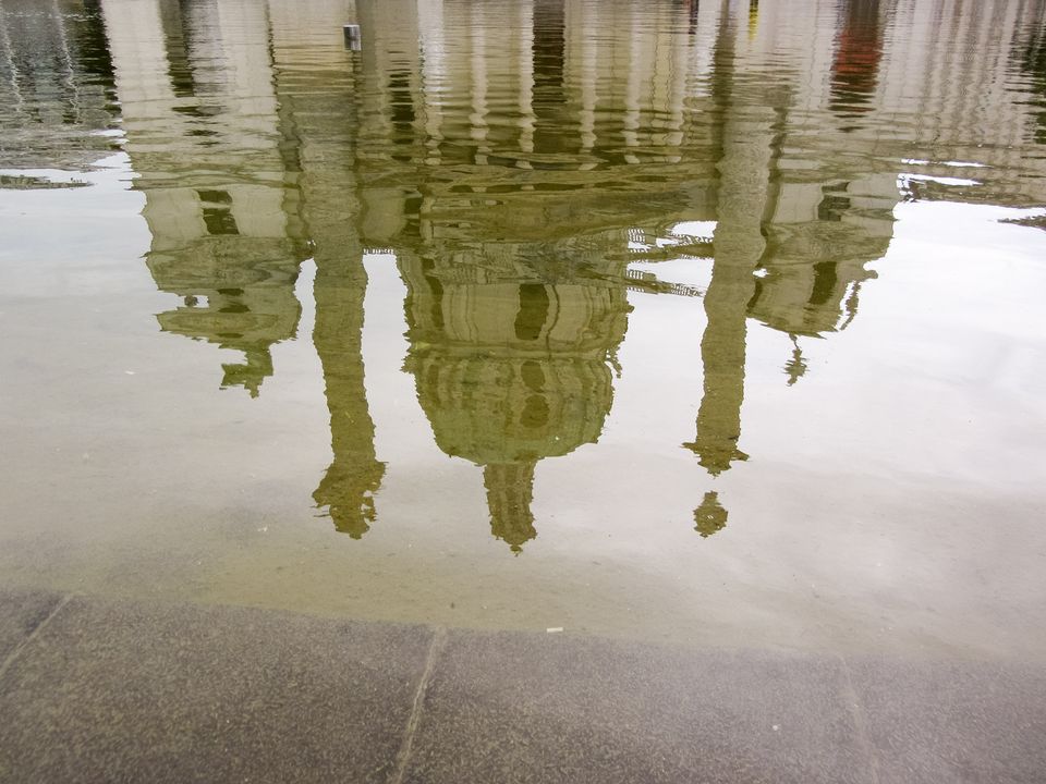 Rippled reflection of a church dome and columns in water