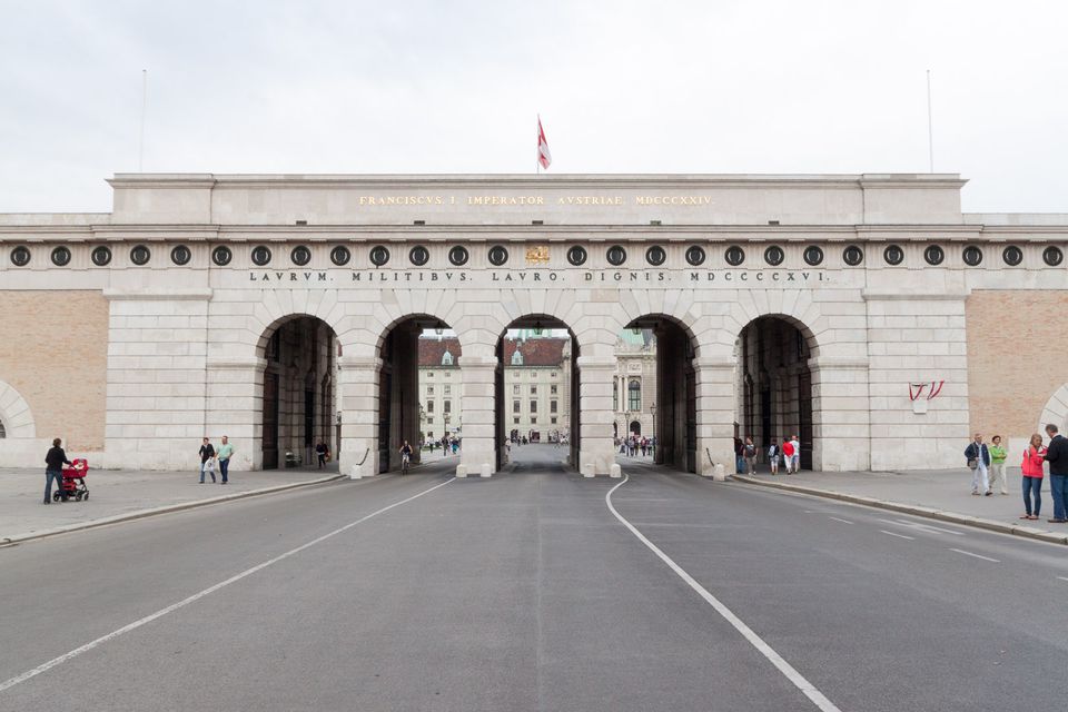 Wide stone gateway with five arches over an empty street