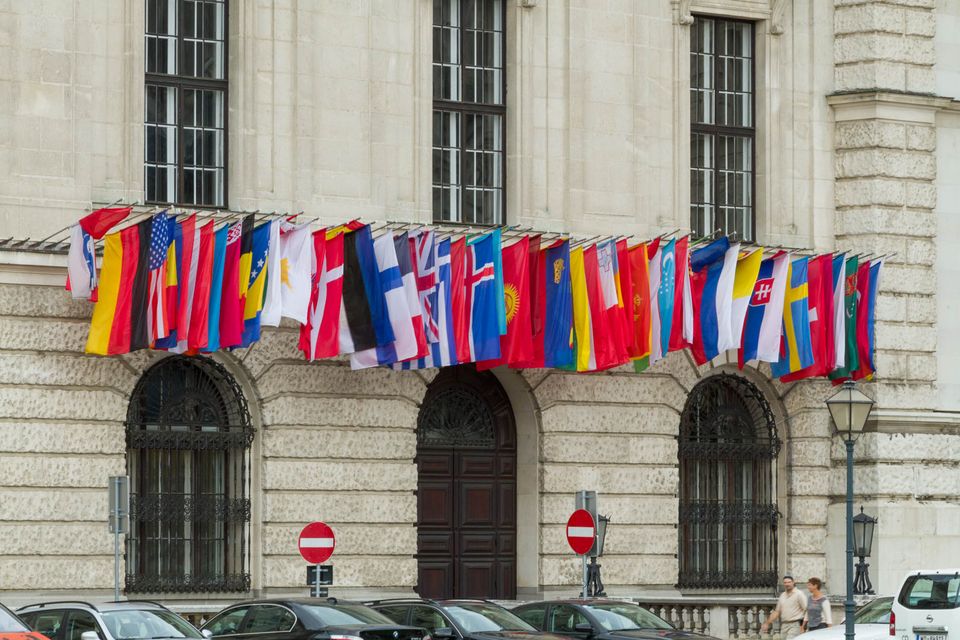Row of national flags strung across a stone facade
